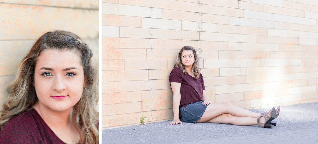 Senior photo in front of a brick wall in downtown Des Moines