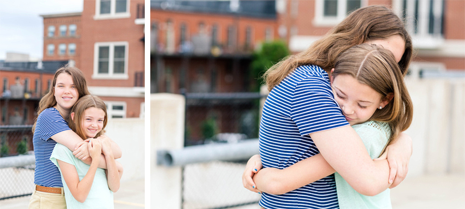 Photo of sisters hugging in family portrait on top of a parking garage in downtown Des Moines, Iowa